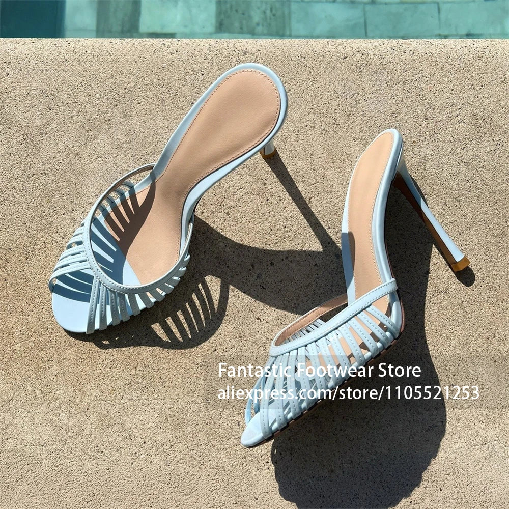 Vivodeco light blue and white strappy mule sandals with open toes, slim high stiletto heels, and rounded fronts displayed on a sunlit textured surface