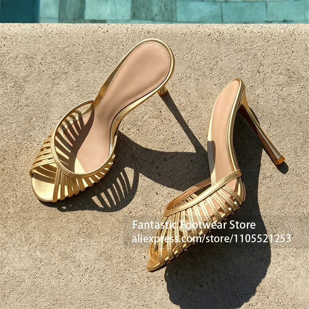 Vivodeco yellow gold mule sandals with delicate strappy open toes and slim stiletto heels displayed on sunlit concrete paving