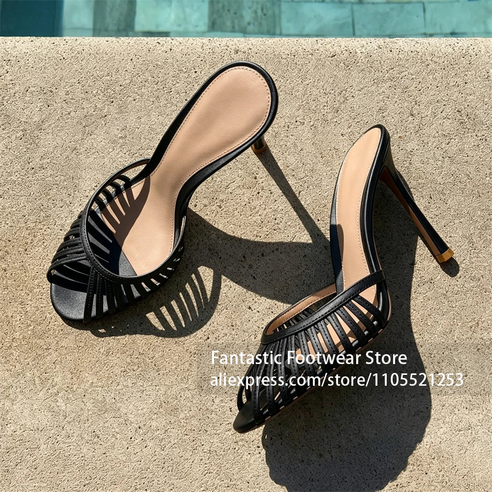 Vivodeco black strappy mule sandals with open toes and slim stiletto heels displayed on a sunlit concrete surface with strong shadows
